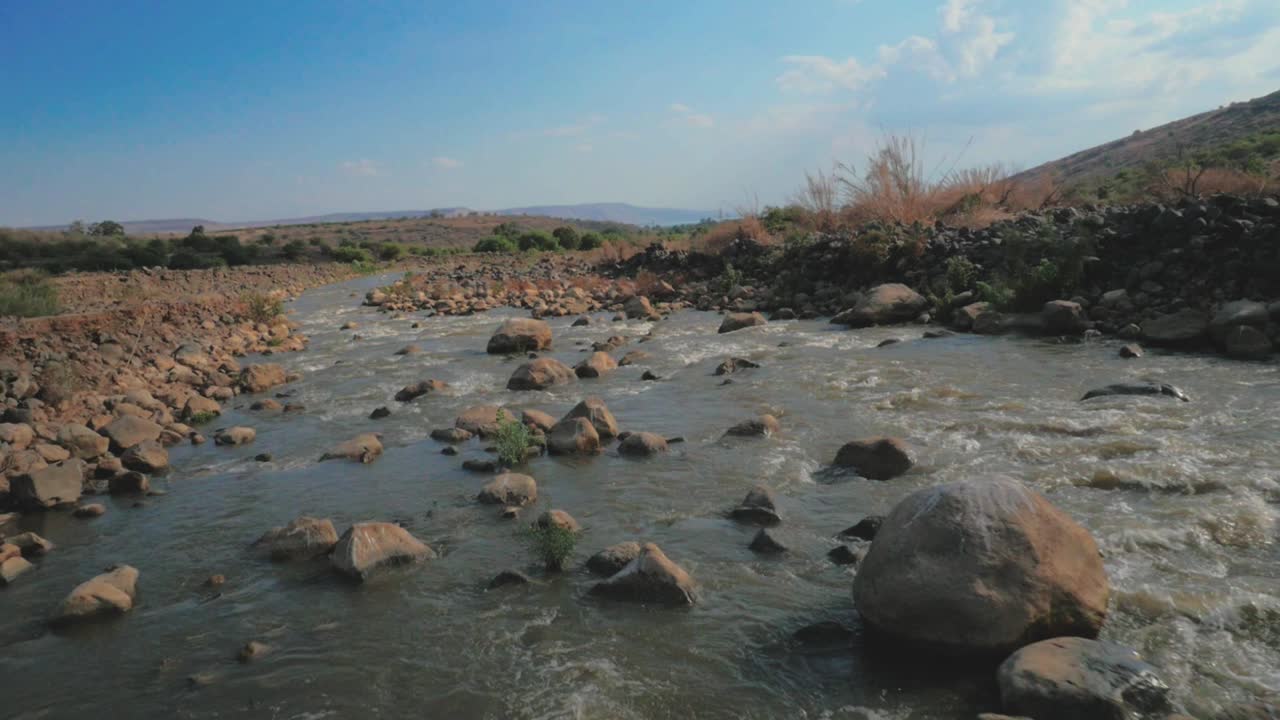 volando sobre el río que fluye rocoso en ángulo bajo pov