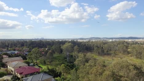 Aufsteigende-Aufnahme-Einer-Luftdrohne,-Um-Brisbane-CBD-Im-Hintergrund-Mit-Kleinen-Flugzeugen-Zu-Enthüllen