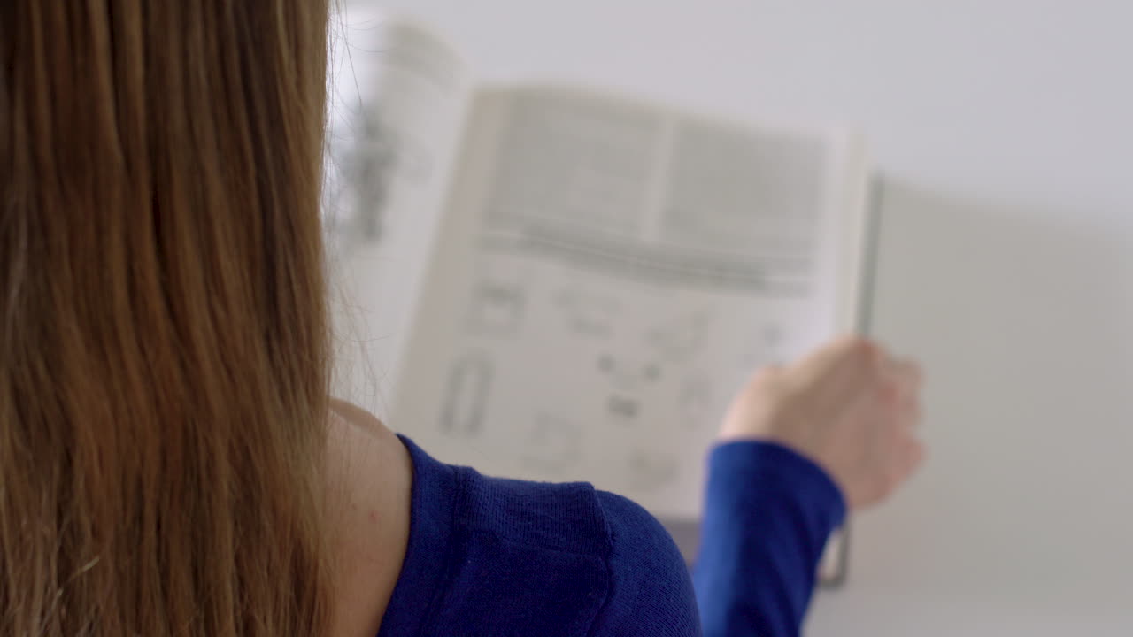 una mujer pasa con los dedos las páginas de un libro