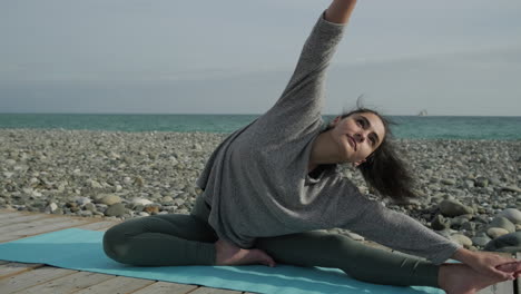 mujer practicando yoga en la playa