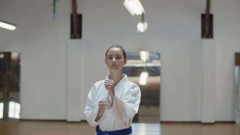 front view of serious girl performing basic karate stances