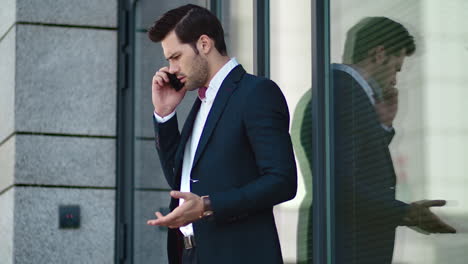 Hombre-De-Primer-Plano-Discutiendo-Por-Teléfono-En-La-Calle.-Hombre-De-Negocios-Hablando-Por-Teléfono-Cerca-Del-Edificio