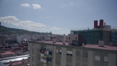 Vista-De-La-Repisa-Del-Edificio-Mientras-La-Ropa-Cuelga,-Visión-General-De-Barcelona,-España,-Temprano-En-La-Mañana-Mientras-Los-Pájaros-Vuelan-A-Lo-Largo-Del-Horizonte-De-La-Ciudad-En-6k