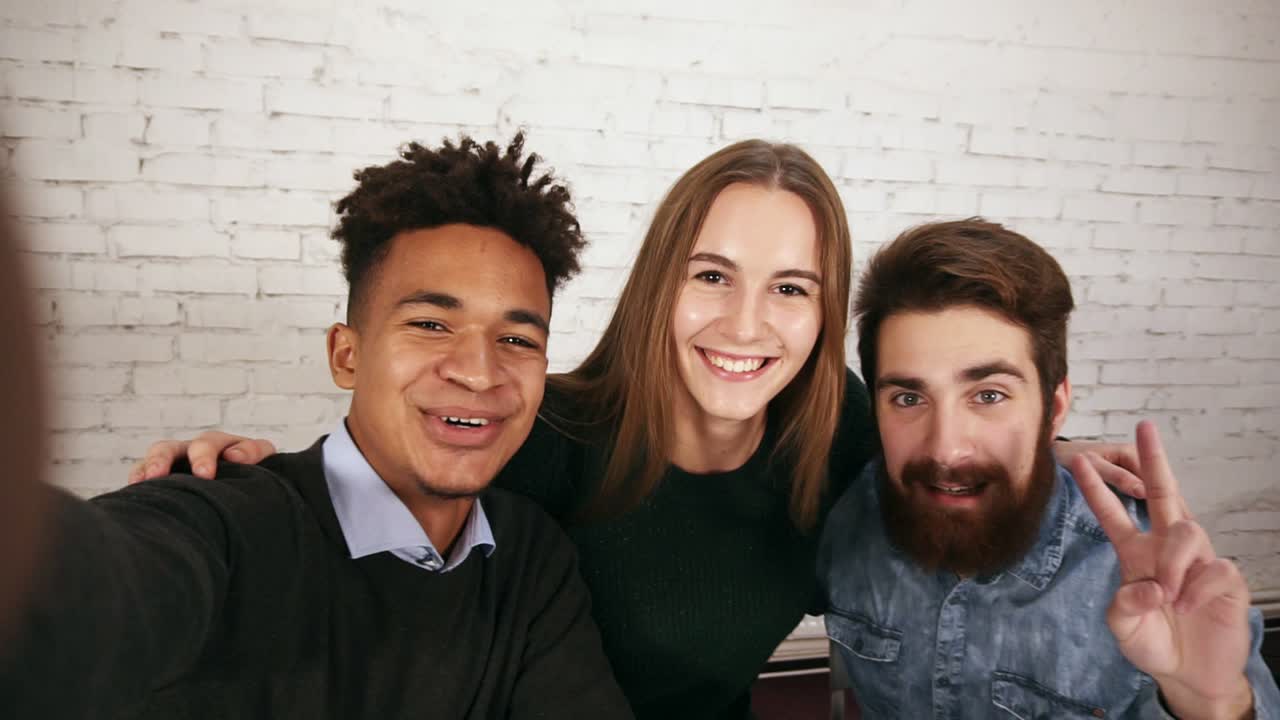 equipo de negocios creativo diverso en una oficina moderna posa para una selfie con un teléfono. retrato de un equipo de negocios casual sonriente tomando