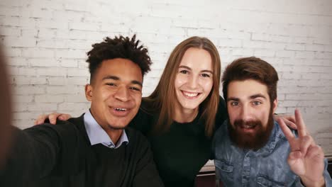 creative diverse business team in modern office pose for selfie with a phone. portrait of smiling casual business team taking