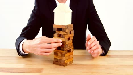hombre de negocios colocando un bloque de madera en una torre