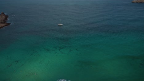 Yacht-boat-sailing-ship-at-pristine-deep-blue-clear-water-beach-bay-coast-on-Palma-de-Mallorca-Island