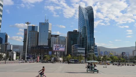 a sunny day at sukhbaatar square, featuring the damdin sukhbaatar statue and modern buildings, such as the blue sky building, in the background in ulaanbaatar, mongolia.