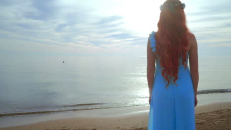 woman on sea beach. redhead woman looking at sea. woman dreaming