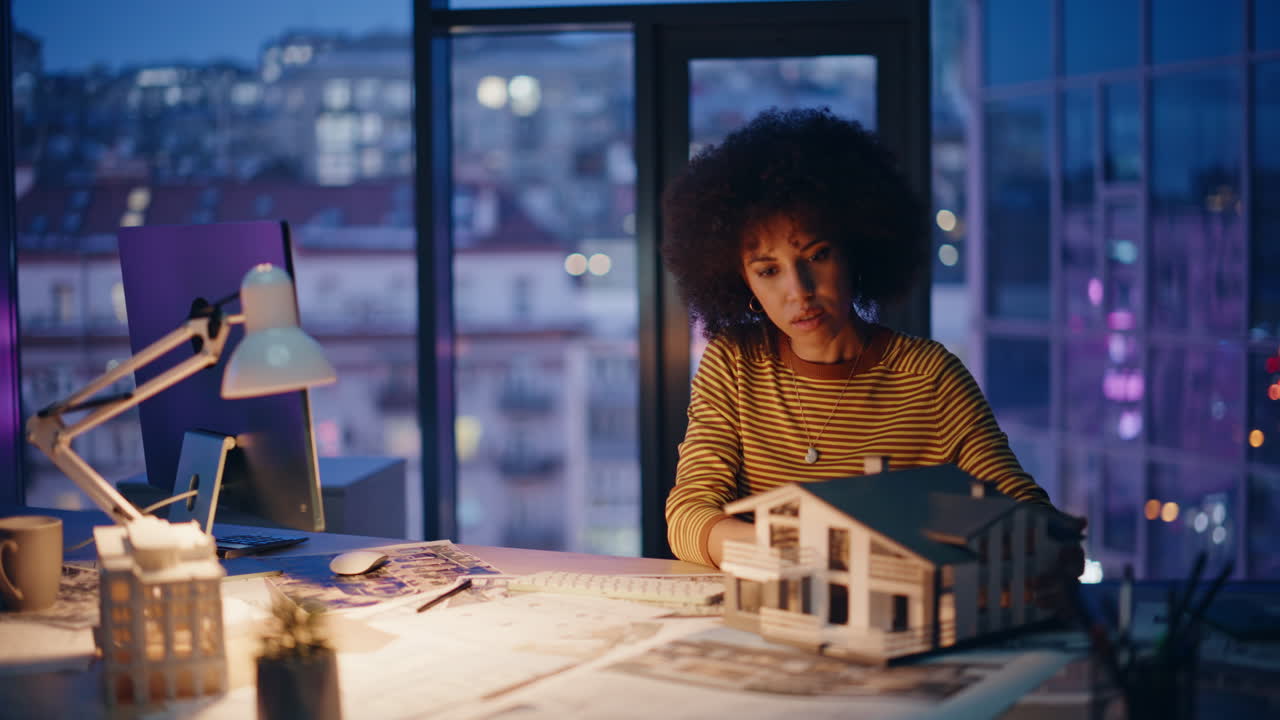 Late worker planning architectural design at office with evening view closeup