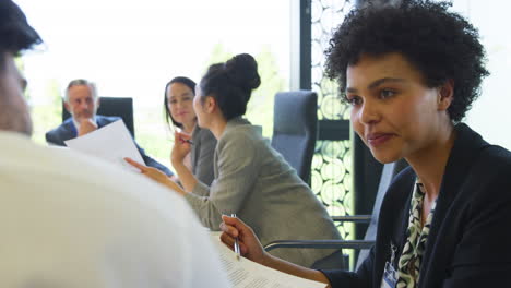 multi-cultural business team meeting and collaborating around table in modern office building