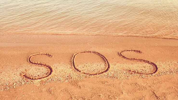 L'iscrizione SOS sulla sabbia. Riprese sulla spiaggia
