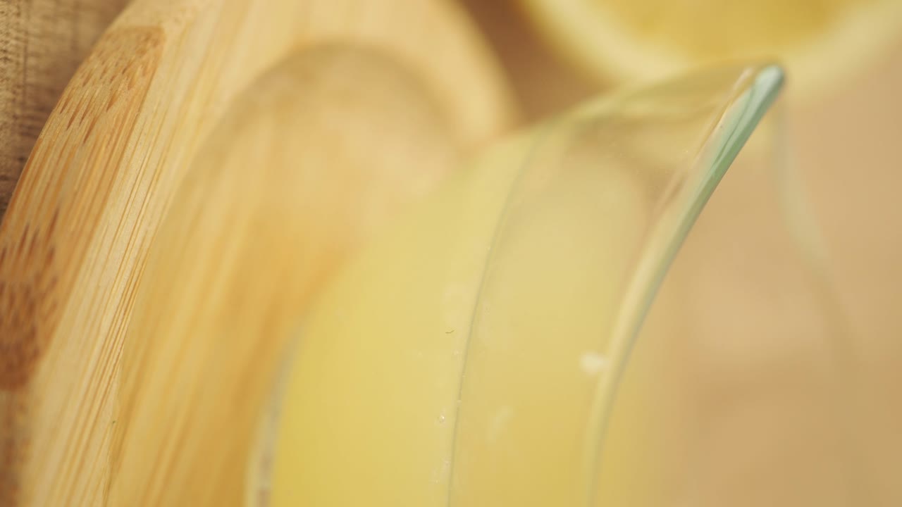 Close-up of a glass with yellow liquid on a wooden surface