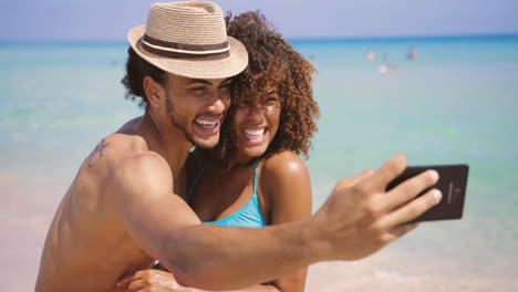 Cheerful-happy-couple-selfies-on-beach