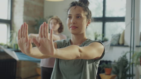 woman flexing wrists on yoga class
