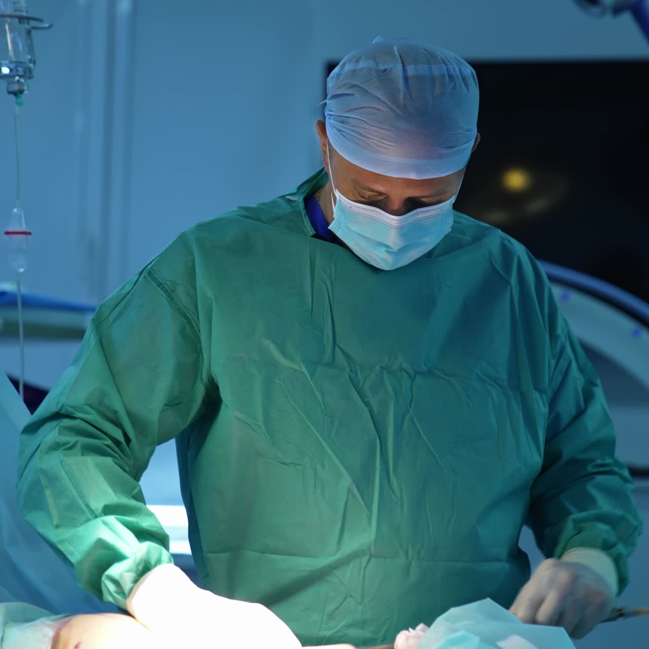 Doctor doing liposuction in operating room. Surgical intervention for removing excessive fat from abdomen. Portrait of a plastic surgeon at work in clinic