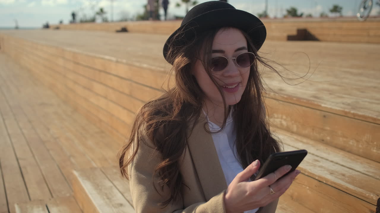 Donna che usa il telefono su scale di legno