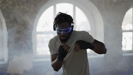 man practicing shadowboxing in sport studio wearing stylish glasses, accelerated footage