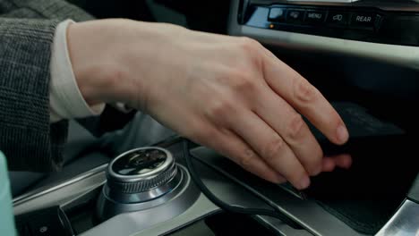 person charging phone in car center console