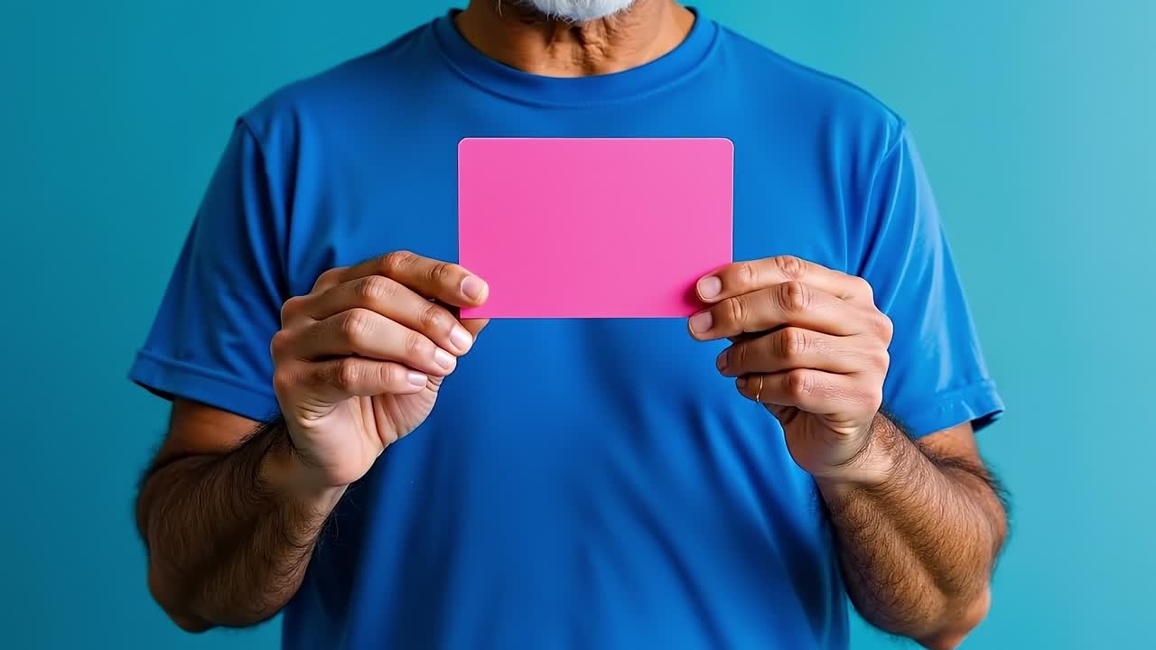 A man holding a pink card in his hands