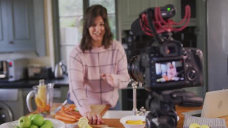 caucasian vlogger woman doing a cooking video at home