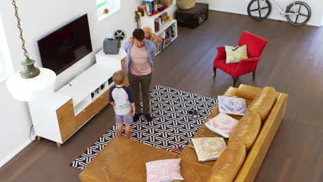 overhead shot of father playing with children in lounge