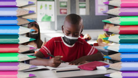 animation of crayons over diverse schoolchildren wearing face masks