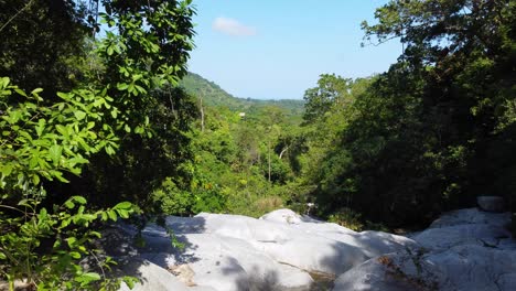 Vuele-A-Través-De-Una-Toma-De-Drones-Del-Lecho-Seco-Del-Río-Que-Fluye-A-Través-De-Una-Exuberante-Selva-Tropical-Ubicada-En-Santa-Marta,-Colombia-En-América-Del-Sur