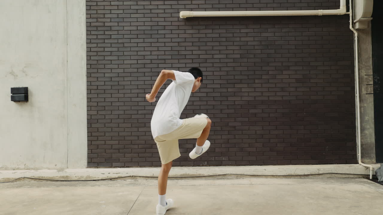 A person juggling a soccer ball in an outdoor setting