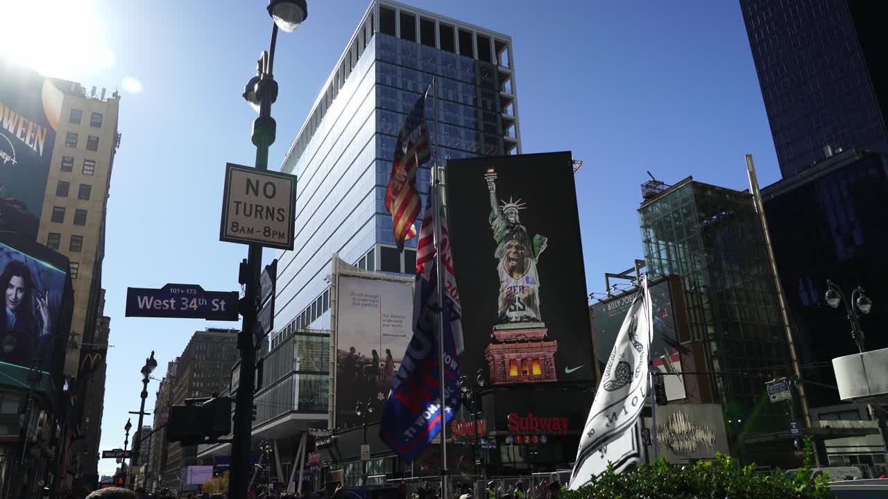 The Trump flag flutters boldly against the clear blue sky, sunlight catching every fold as it waves above the New York skyline