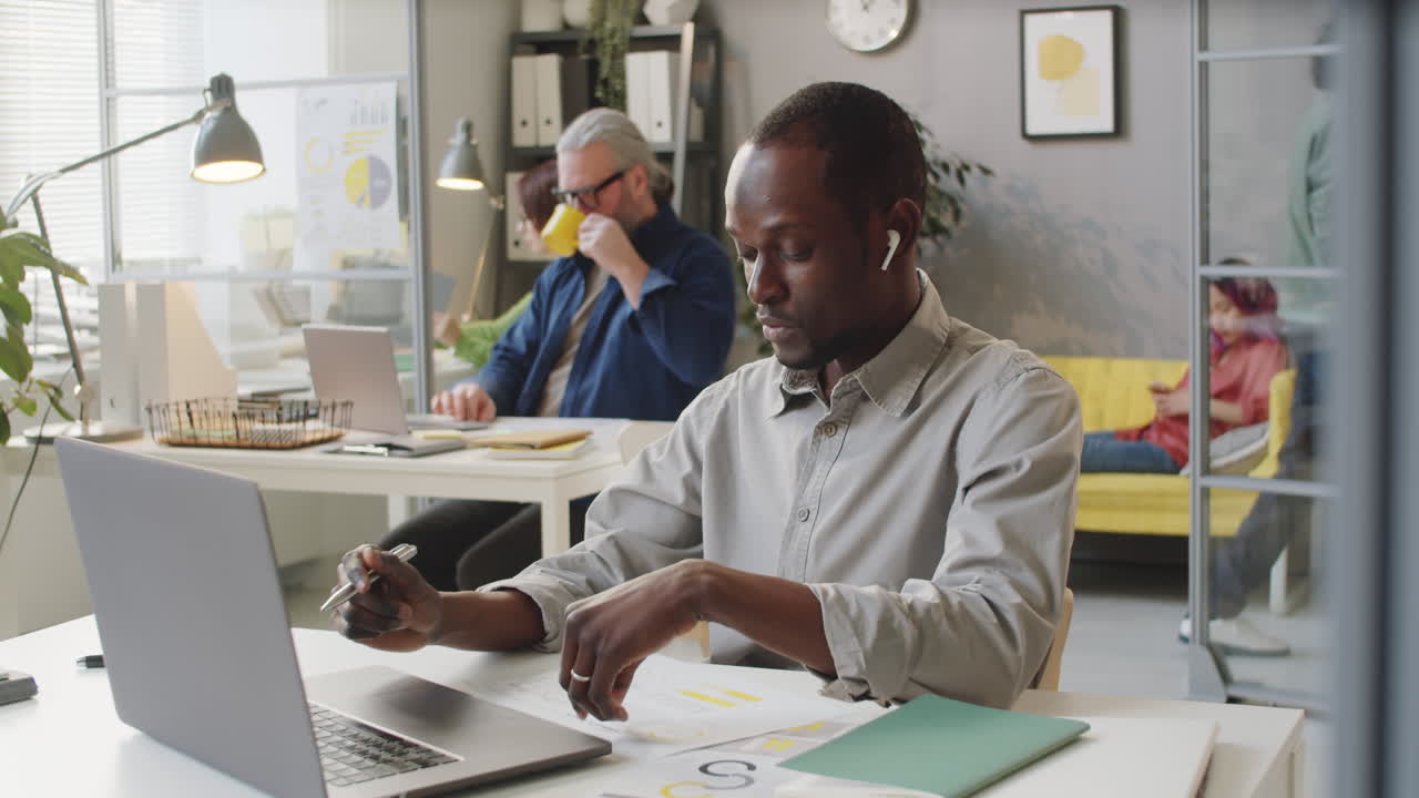 Employé de bureau afro-américain discutant un document en visioconférence