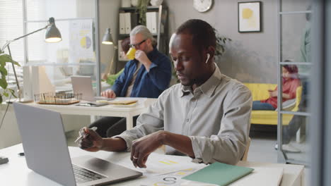 african american male office worker discussing document on video call