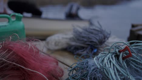 fishnets and ropes on the wooden plank beside the lake in norway