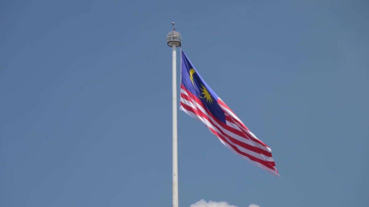 Bandiera malese al vento sull'enorme palo in piazza Merdeka, Kuala Lumpur, Malesia