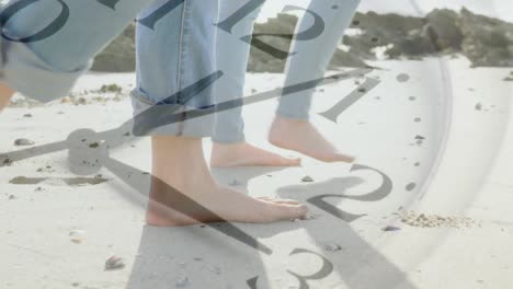 composite video of ticking clock against low section of a caucasian couple walking on the beach