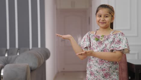 happy indian kid pointing left for copyspace for product placement