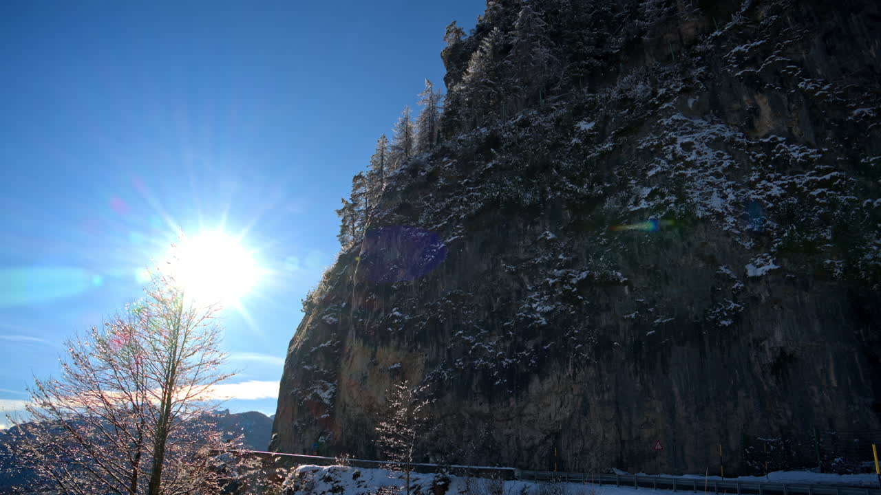 View of snow on the trees and mountains in the Dolomites, Italy with the cloudy sky on the background