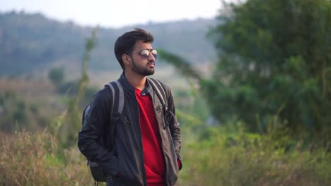 indian young man alone slowly walking on sidewalk in dark evening