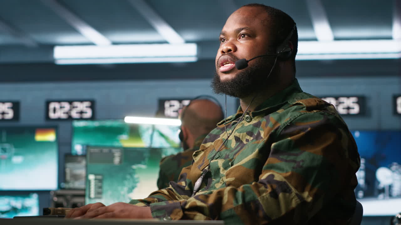 Military dispatcher managing communications networks, looking at screens