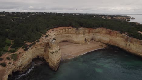 Aerial-view-static-shot-over-Benagil-caves,-Lagoa,-Algarve-Portugal-with-Atlantic-ocean-transparent-coastline