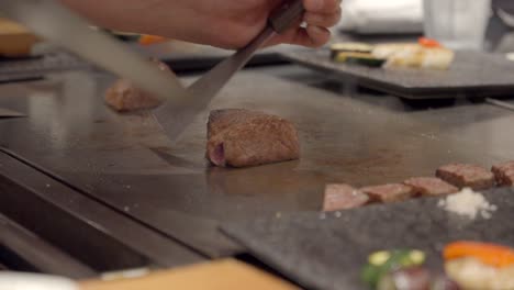 japan chef cut slice kobe wagyu meat over teppanyaki table in front of guest shot marble certified authentic japanese