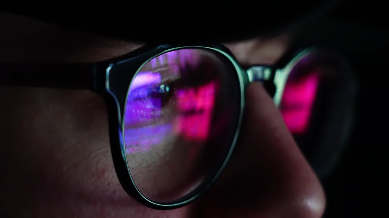 hombre en su computadora por la noche luz azul ultravioleta golpeando gafas - primer plano de mano