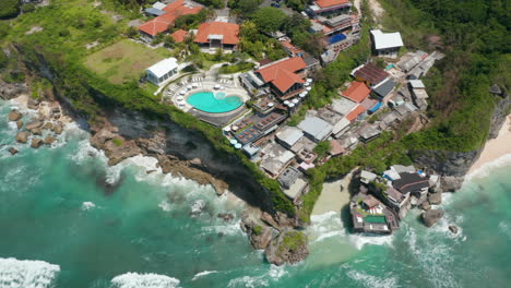 Vista-Aérea-Del-Resort-Tropical-De-Lujo-Y-Villas-Con-Piscina-En-El-Acantilado-Sobre-El-Mar-Azul-Turquesa-En-Bali,-Indonesia