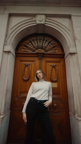 woman in front of an ornate wooden door