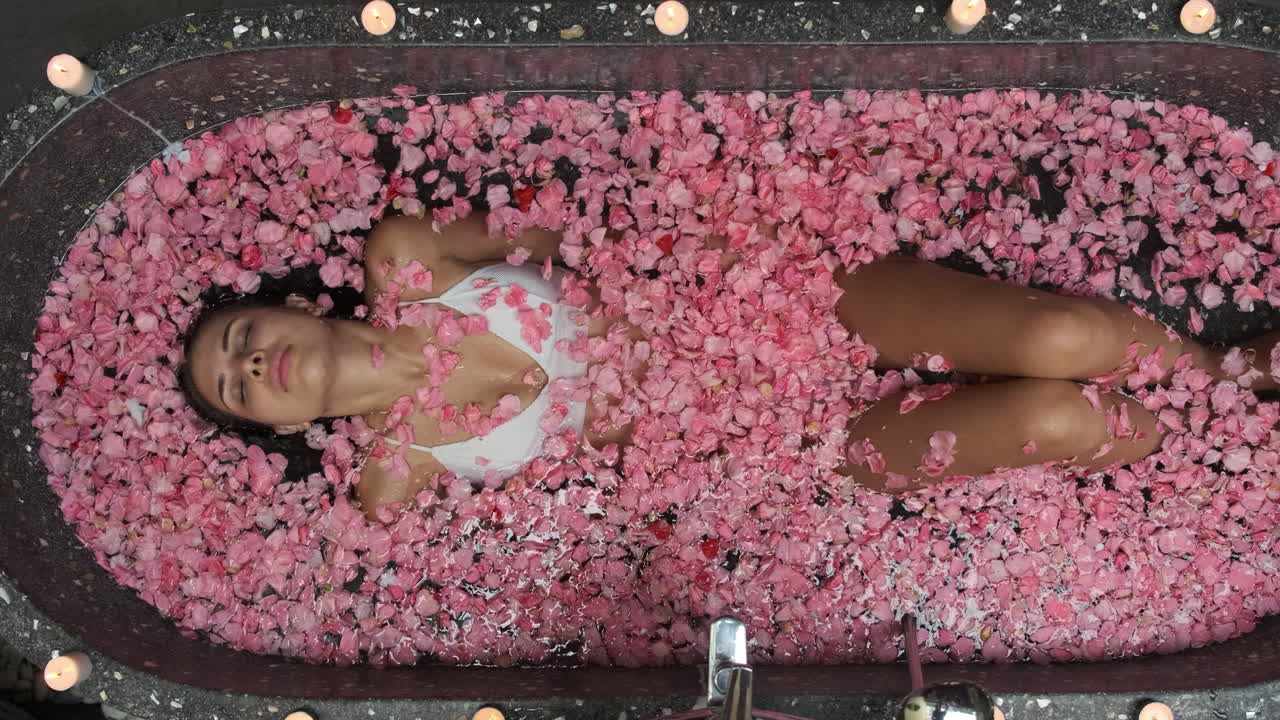 Woman relaxing in a rose petal bath