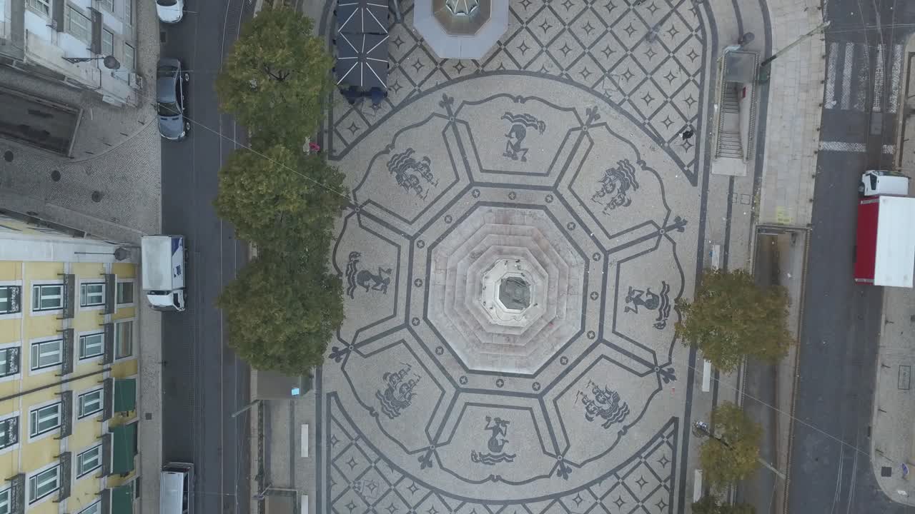 Aerial shot captures the scenic Cam&otilde;es Square in Chiado, Lisbon, Portugal, showcasing its architectural charm and the vibrant ambiance of the area