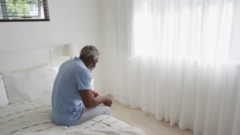 stressed senior man sitting on the bed at home