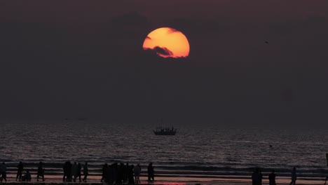 El-Sol-Anaranjado-Y-El-Cielo-De-La-Puesta-Del-Sol-Revelan-Lentamente-La-Silueta-De-La-Gente-En-La-Playa-De-Karachi