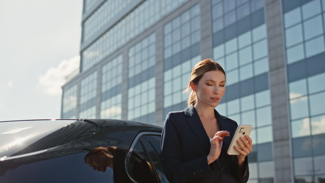 la señora jefe navegando en la aplicación en el teléfono inteligente cerca del edificio de oficinas de primer plano. mujer elegante