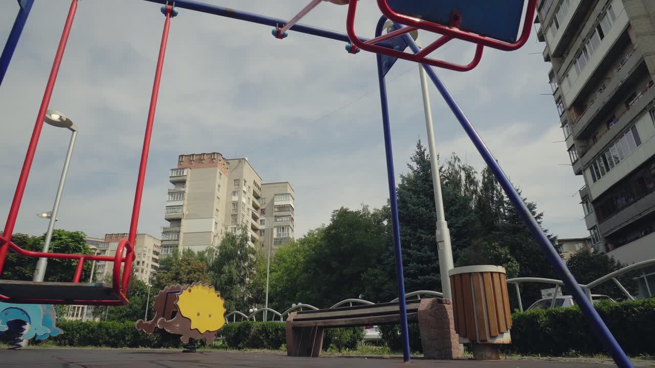 A boy swings on a swing in the city 03